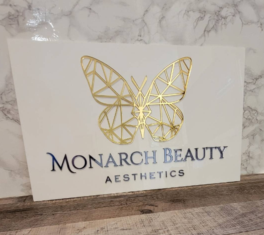 White and gold acrylic sign for Monarch beauty